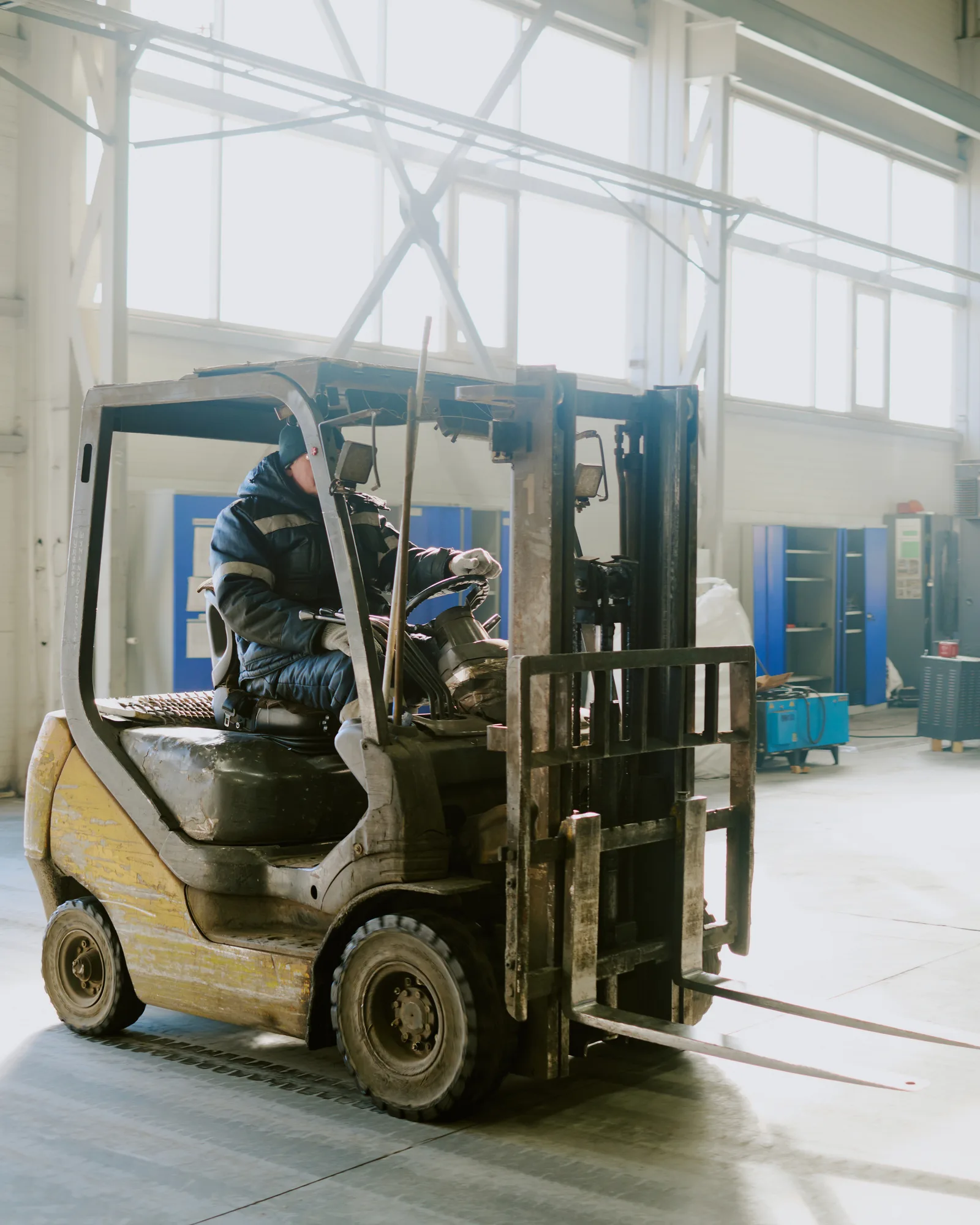 Forklift operator moving materials inside a manufacturing facility